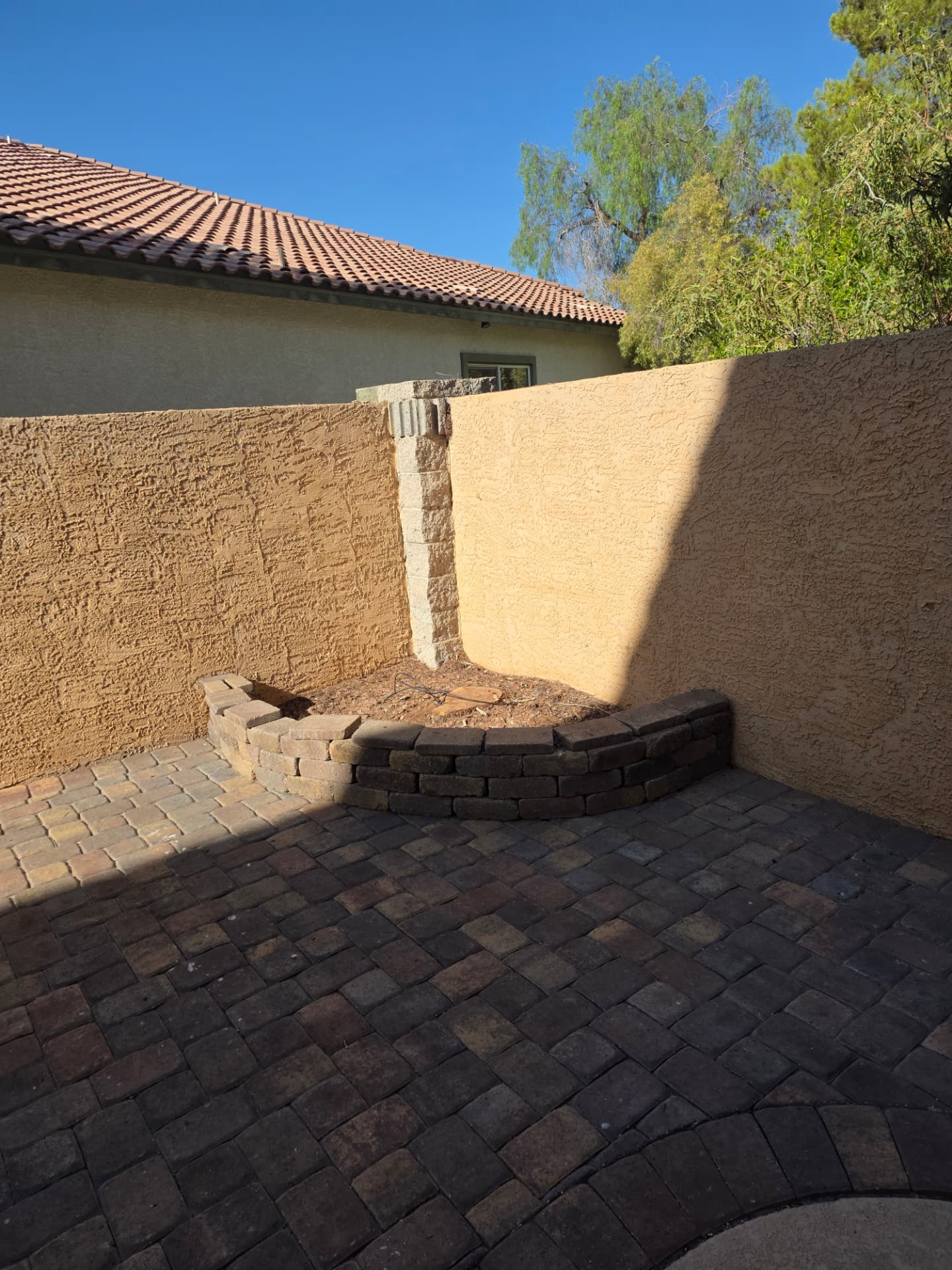 Cleared patio corner and planter after the dead tree was removed